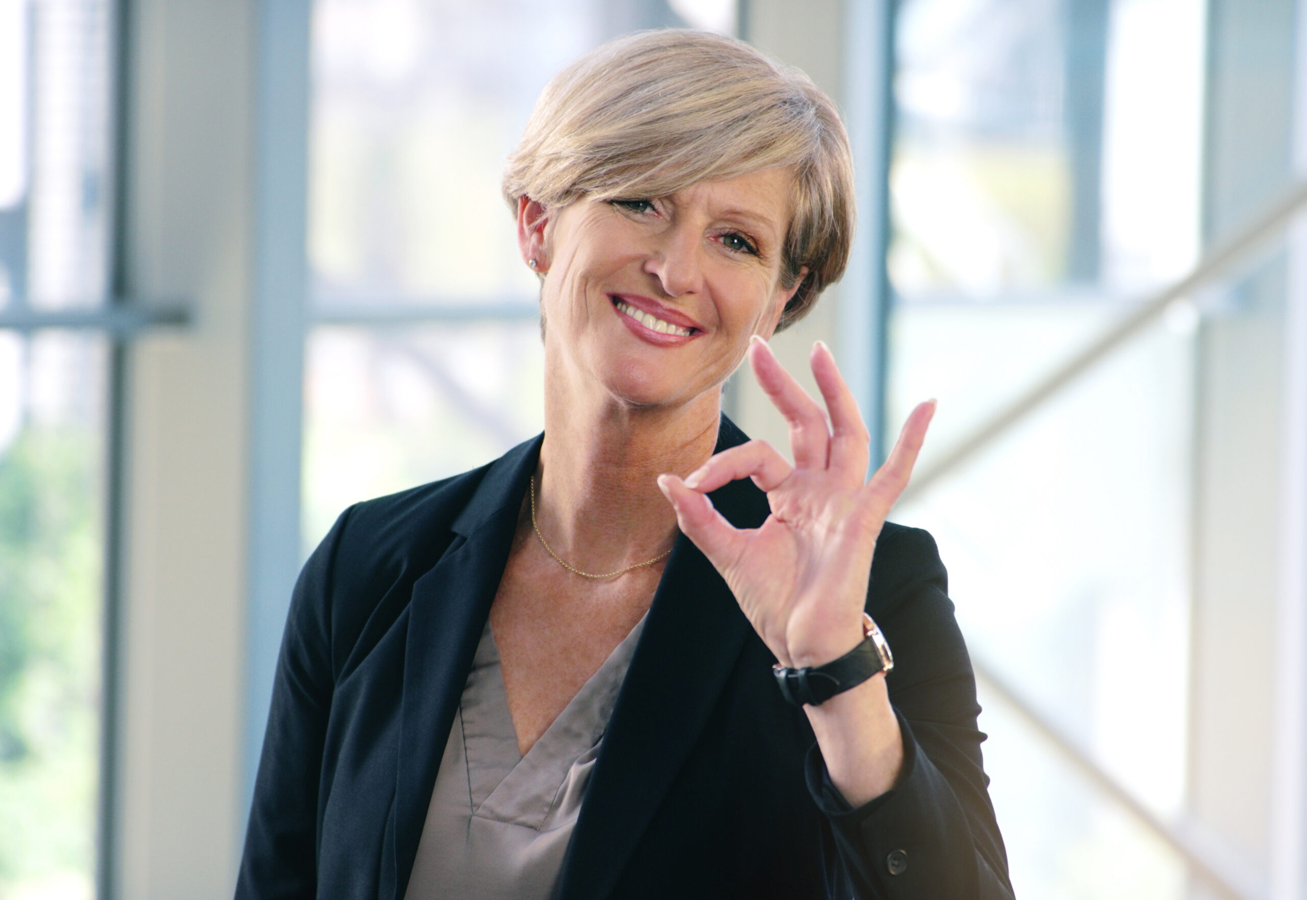 Portrait, smile and business woman with ok sign in office for success, agreement or yes. Face, mature and female professional with okay hand gesture, emoji or perfect, excellence or thank you at work.